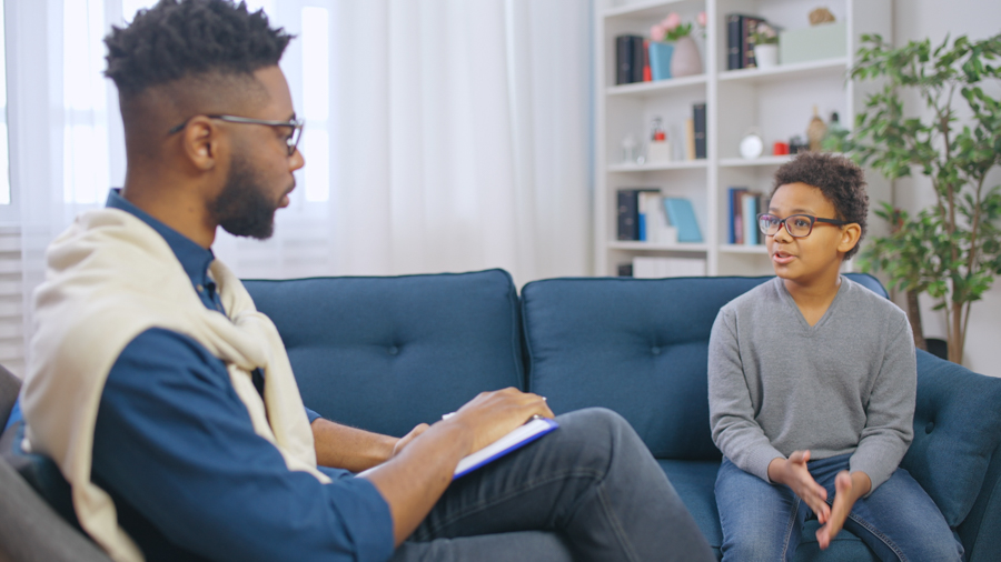 Pre-teen boy talking to school psychologist, adolescent counseli